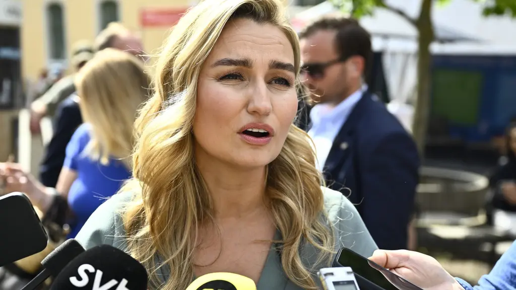 Ebba Busch (KD) möter pressen under Almedalsveckan i Visby. Flera mikrofoner och en mobil hålls fram när partiledaren intervjuas utomhus.