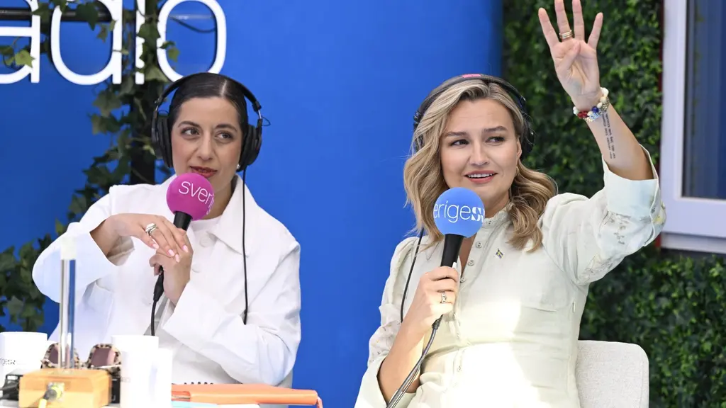 Liberalernas Simona Mohamsson och KD-ledaren Ebba Busch intervjuas i Sveriges Radios studio under Almedalsveckan i Visby. Busch vinkar mot publiken.