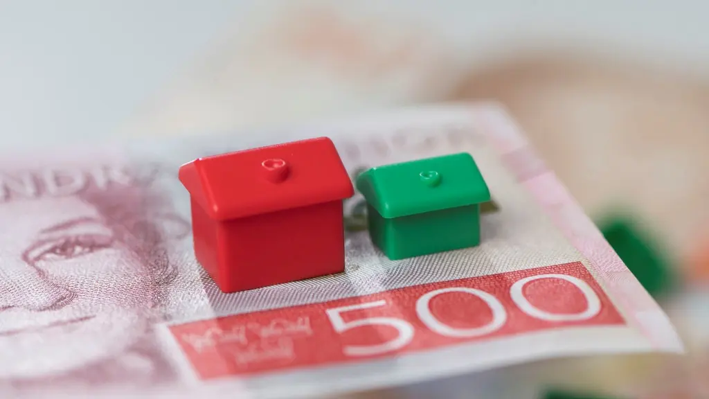 Två små Monopolhus som står på en 500-lapp.