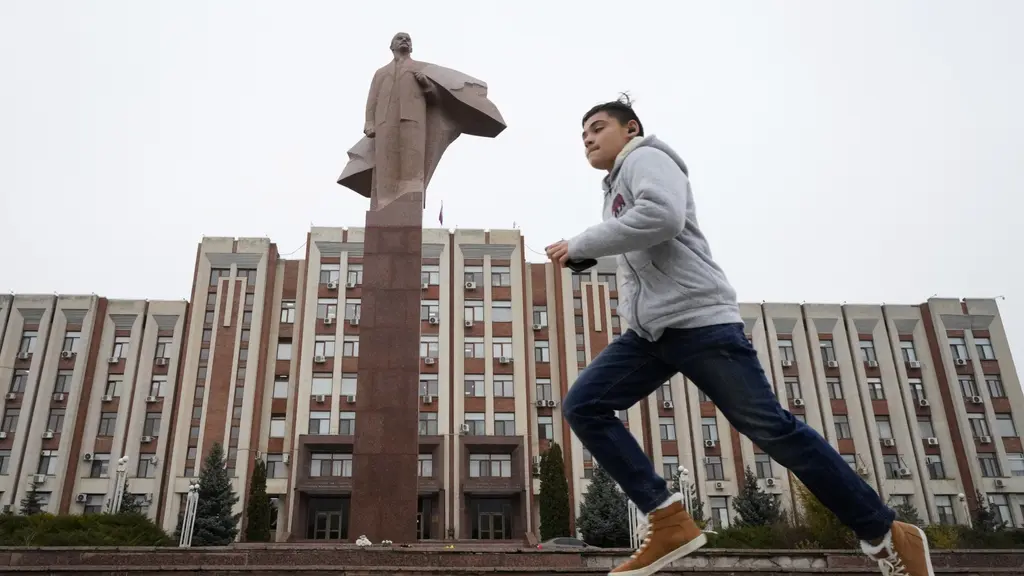En pojke springer förbi en stor staty av Vladimir Lenin i Tiraspol, Transnistriens huvudstad.