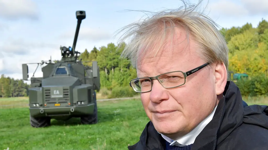 Man framför lastbil med artellerikanon.