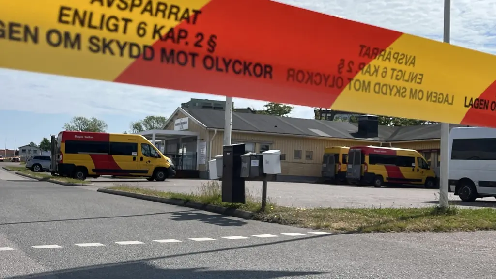 Gulröda bussar och byggnader i bakgrunden, i förgrunden ett plastband med texten Avspärrat enligt lagen om skydd mot olyckor.