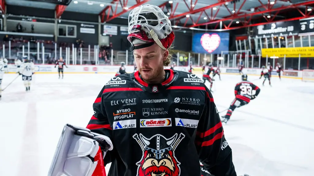 Hockeymålvakt har fällt upp gallret och kommer åkande mot båset.