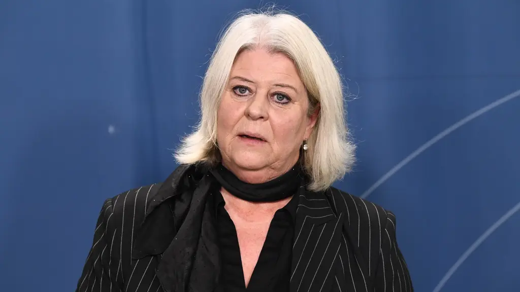 Socialtjänstminister Camilla Waltersson Grönvall står framför en blå bakgrund och talar till media.