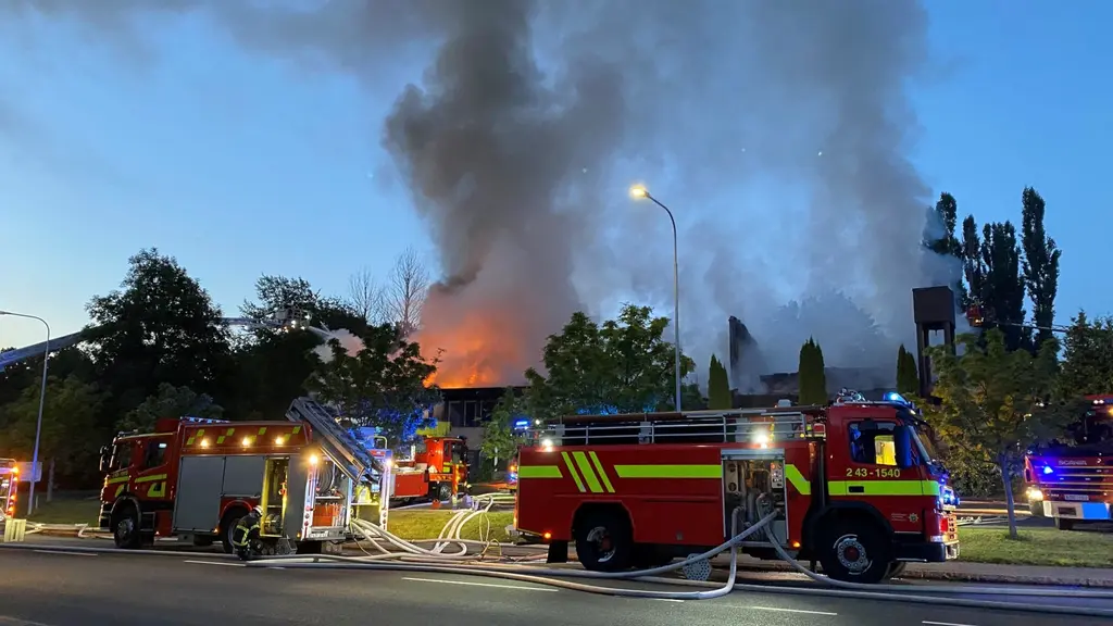 Brand i en kyrka. Två brandbilar står framför.