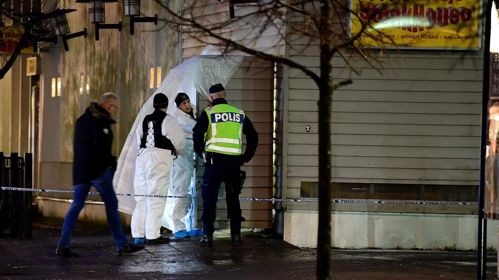 Poliser står vid en avspärrat byggnad.