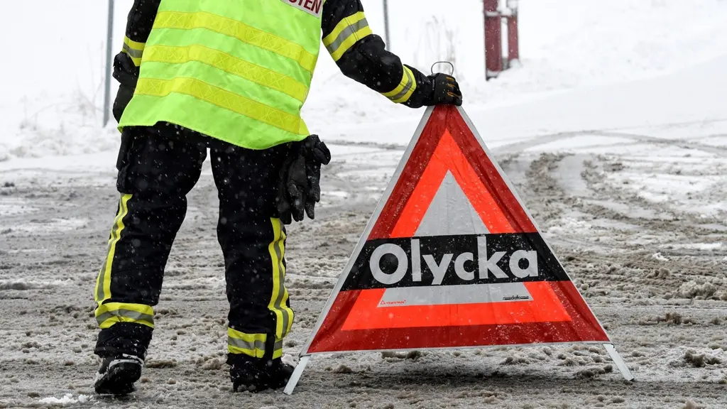 Räddningstjänsten sätter upp en skylt om olycka i vinterväglag.