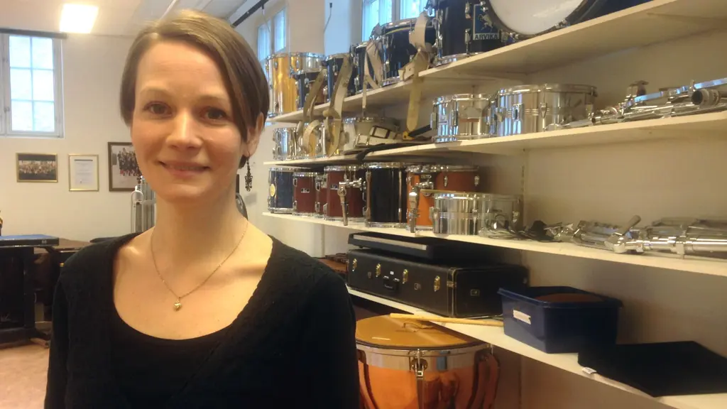 Malin Linell framför hyllor med instrument