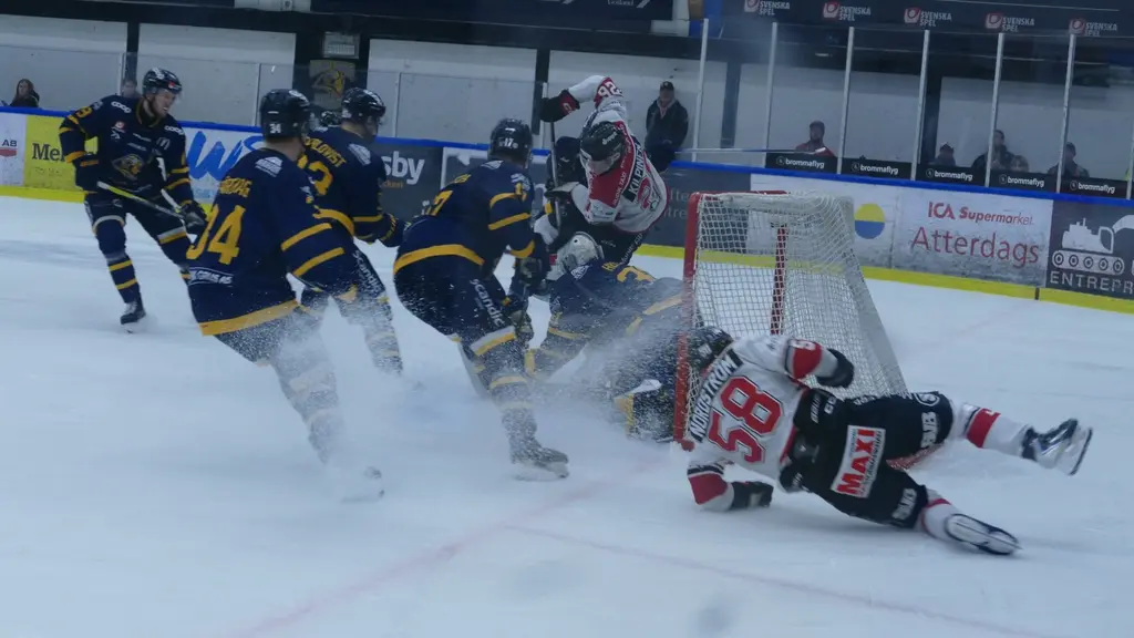 Ishockeymatch mellan Visby Roma och Hudiksvall.  Intensiv kamp nära målburen på isen.