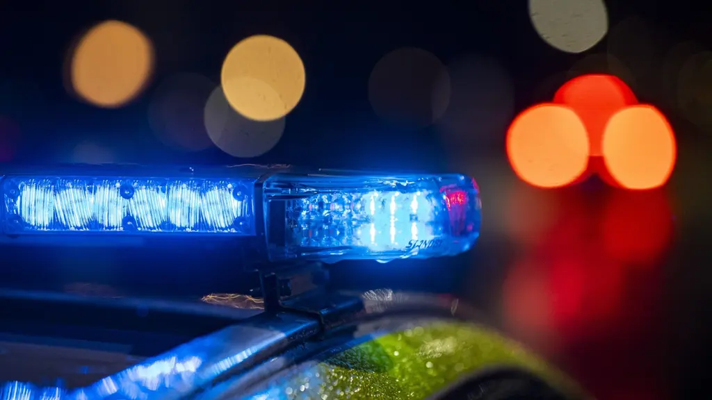 Polisbil på natten med blinkande blåljus