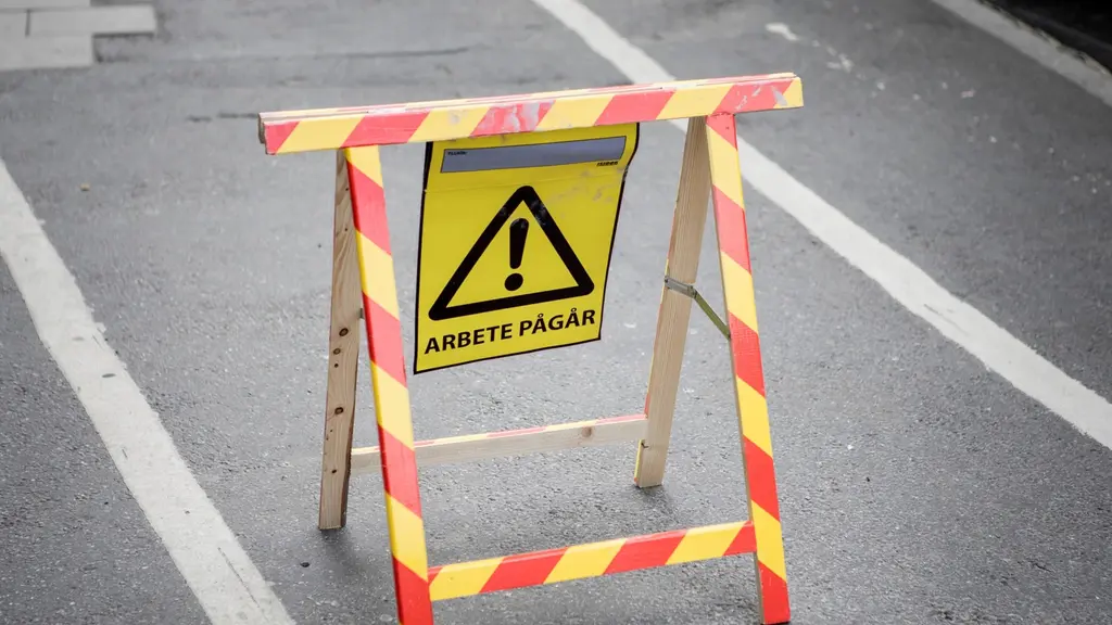 Skylt med utropstecken i triangel där det står "arbete pågår".