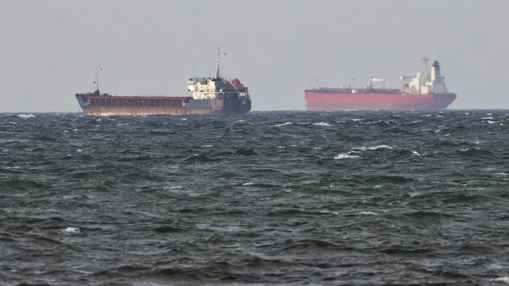 Två fartyg, Caffa och Sea Owl I, ligger ankrade sida vid sida på öppet vatten utanför Trelleborg. Bilden visar ett hav med vågor och de två stora fartygens silhuetter i fjärran. Foto: Johan Nilsson/TT. 
