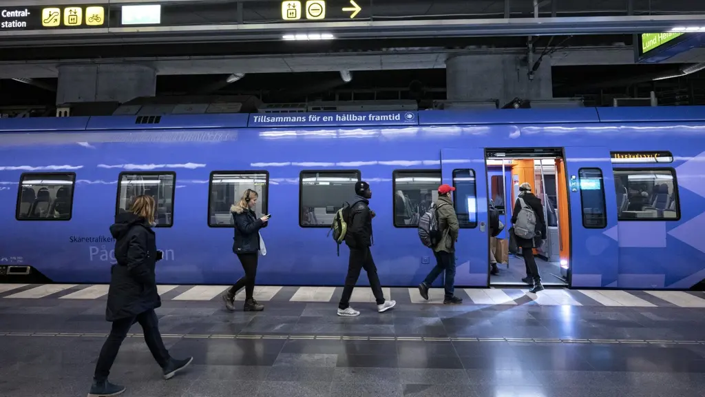 Resenärer på behörigt avstånd från varandra på väg ombord på ett extralångt Pågatåg på Malmö C.