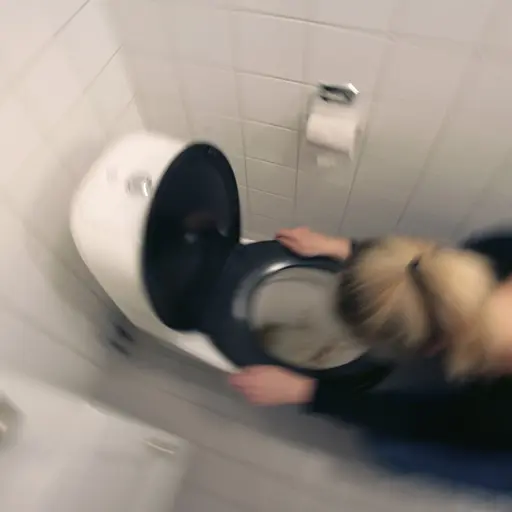 Kvinna kräks i en toalettstol i ett badrum, en illustrativ bild om magsjuka och vinterkräksjuka.