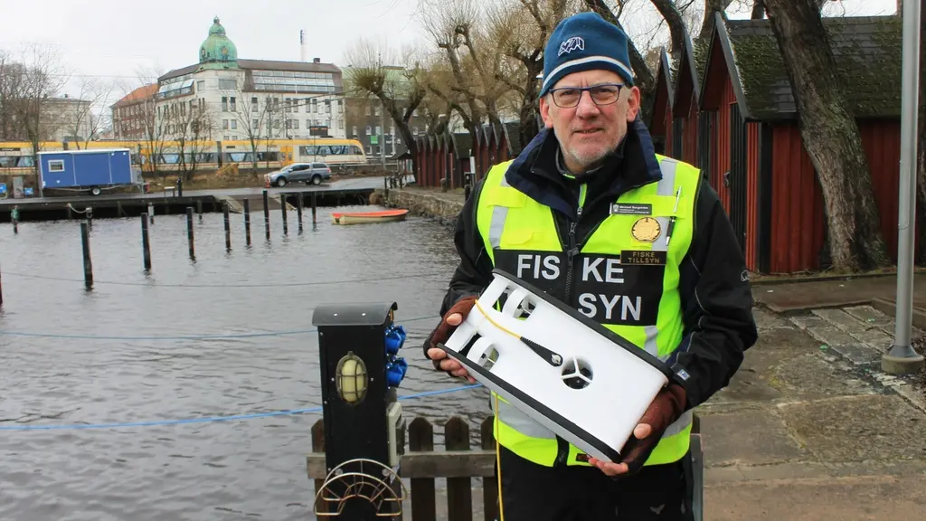 Michael Bergström fiskeritillsyningsman på länsstyrelsen i Jönköping visar den nya undervattenströnaren. Foto: Henrik Dammberg/Sveriges Radio.