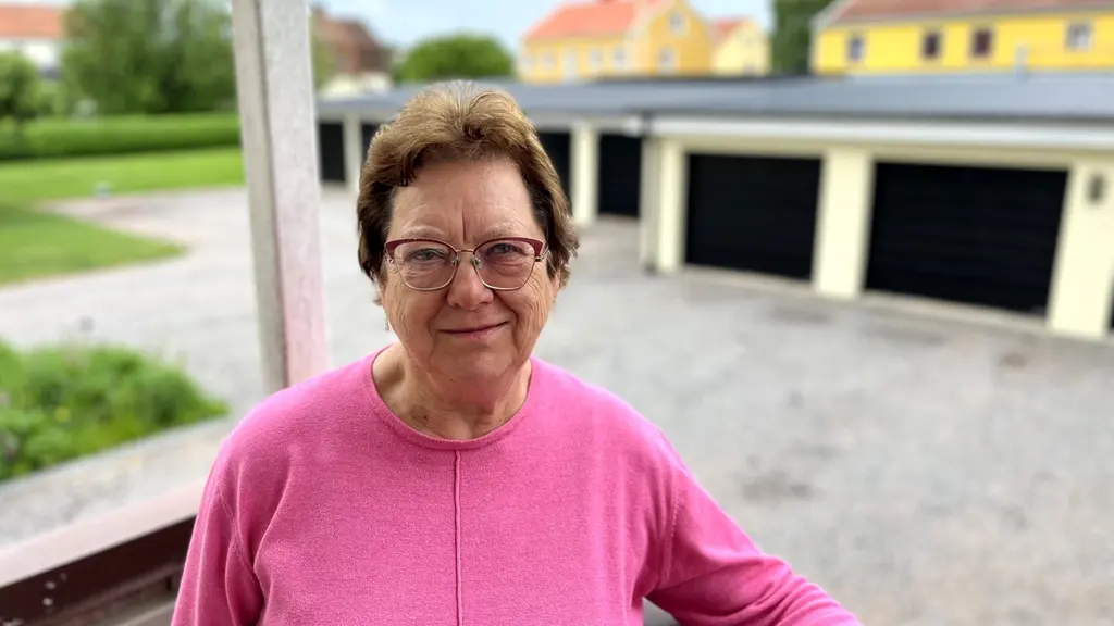 En kvinna i rosa tröja på en balkong.