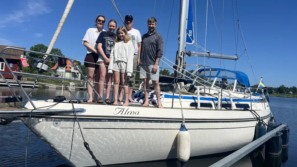 Louise Lindqvist och Fredrik Järnström står med barnen My och Ebba på en segelbåt vid bryggan, inför nio veckors båtliv med familjen.