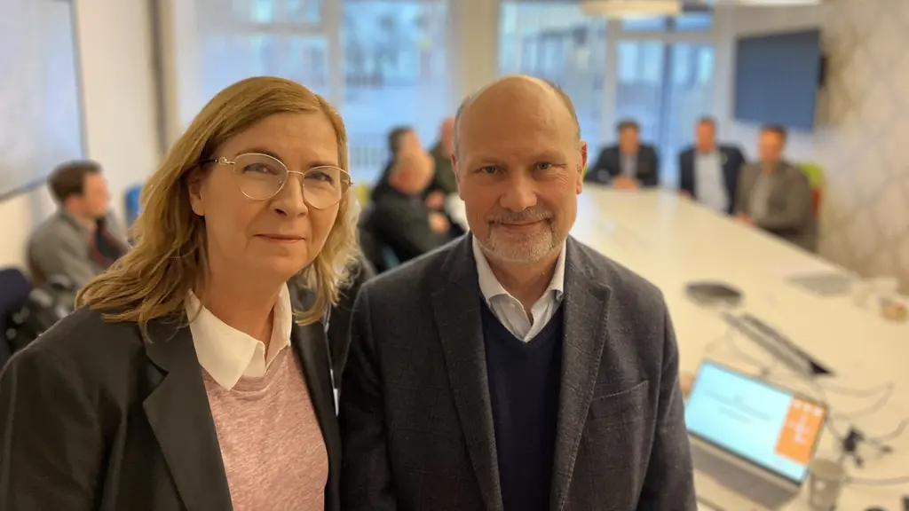 En kvinna och en man i ett mötesrum.