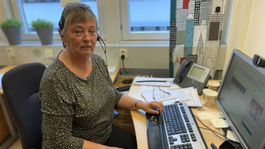 Kvinna med telefonheadset framför dator