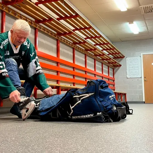 En äldre man med hockeytröja sitter i ett omklädningsrum och knyter sina skridskor. Rummet har röda bänkar och krokar på väggen. En blå hockeyväska ligger på golvet bredvid honom.