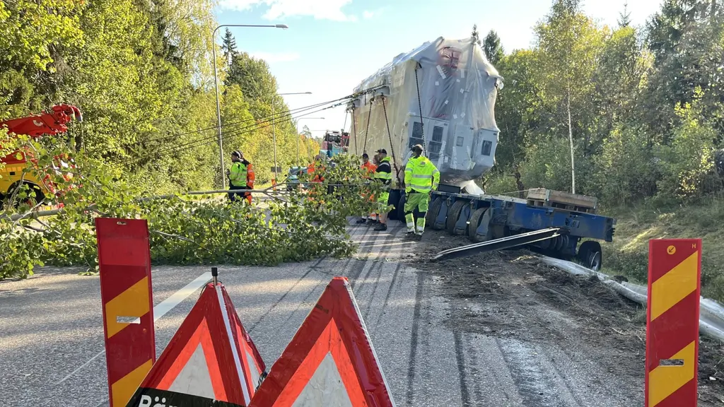En 200 ton tung transformator blockerar en väg i Bomhus, Gävle. Räddningspersonal arbetar med att bärga objektet medan varningsskyltar och avspärrningar omger platsen.