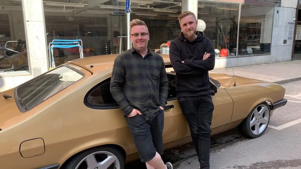 Två killar och en guldfärgad bil.