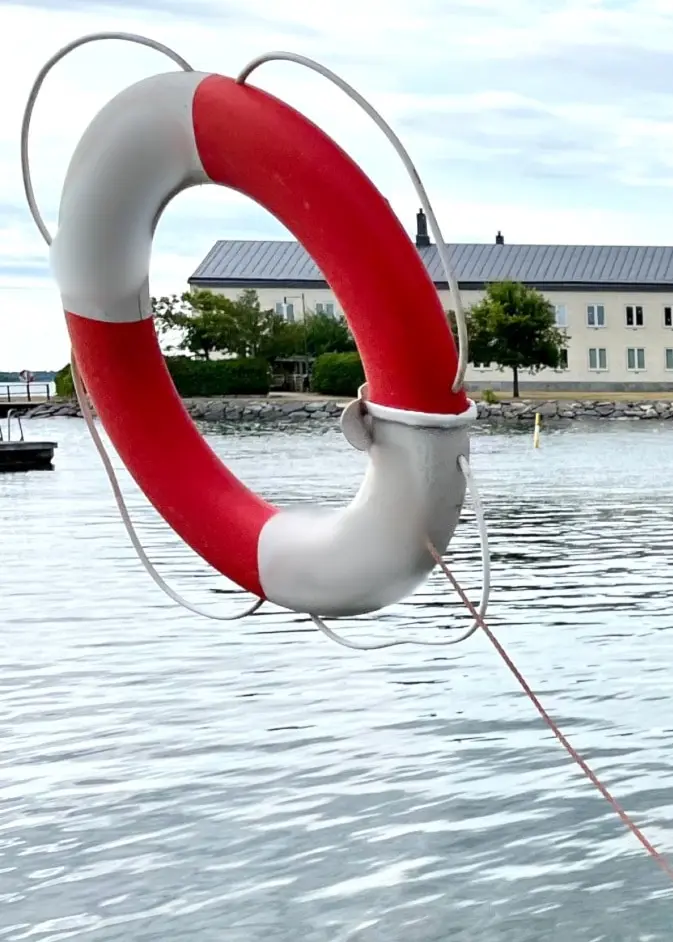 Annette Ludvigsson från Livräddningssällskapet kastar en livboj från kajkanten mot vattnet i en hamn, i en nyhetsbild om vattensäkerhet och livräddning.