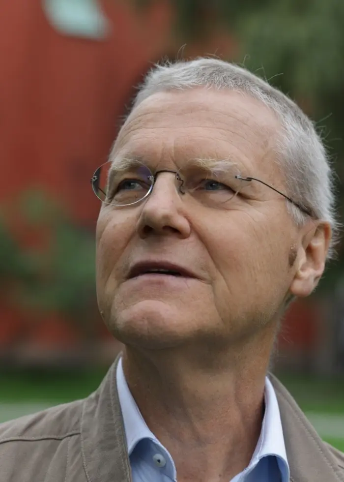 Man i glasögon framför en kyrka