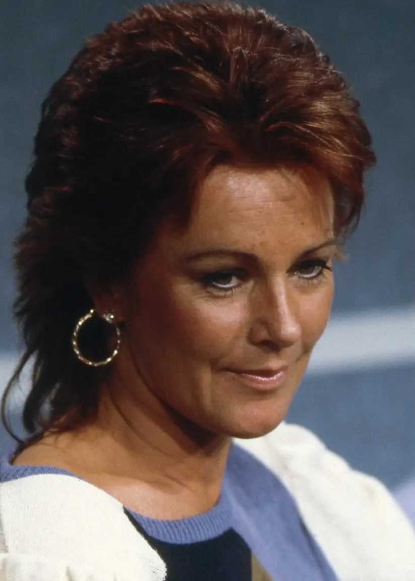 Anni-Frid Lyngstads ansikte syns i profil. Hon bär stora runda örhängen. Åtminstone i det öra som syns.