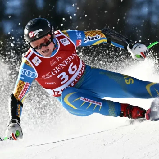 Svensk alpinåkare i blå tävlingsdräkt i en störtloppsbacke