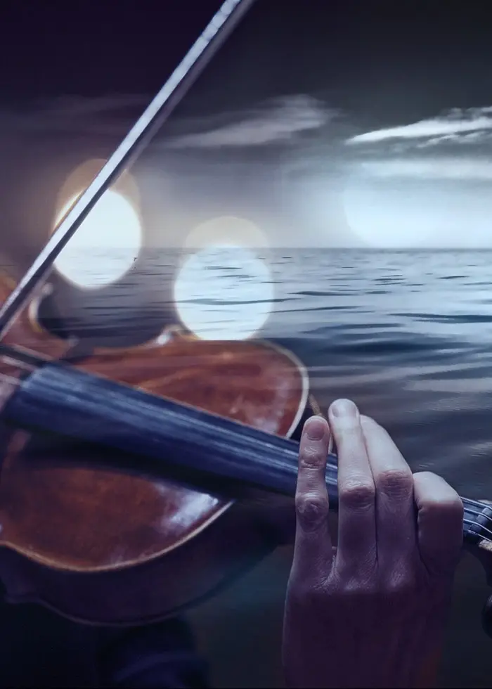 En violinist framför ett hav