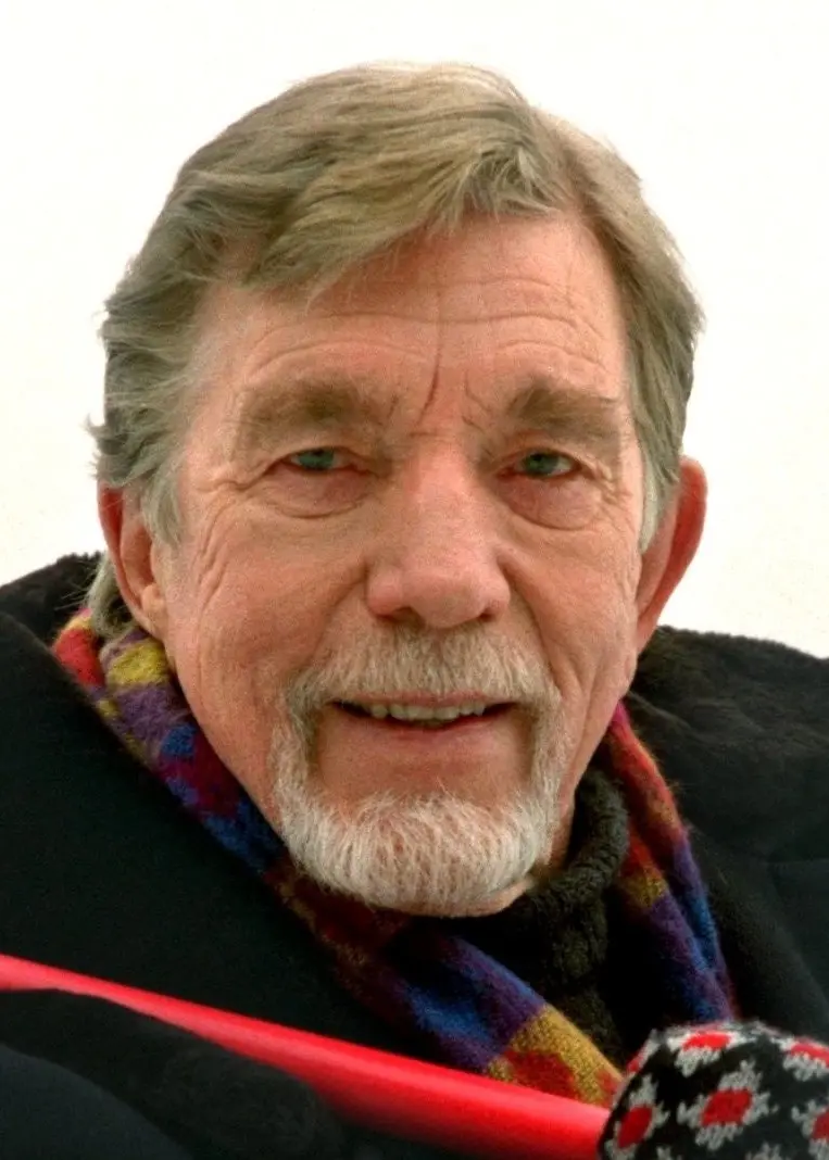 Owe Thörnqvist tittar mot kameran. Han har skägg och mustasch som ramar in munnen. Han verkar vara utomhus av kläderna att döma.