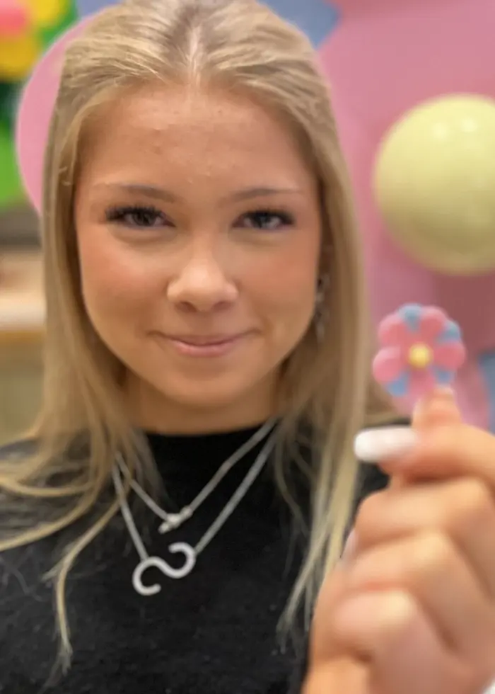 14-åringarna Saga Laventzakis och Leia Sandell håller i varsin majblomma som är ljusblå och rosa.