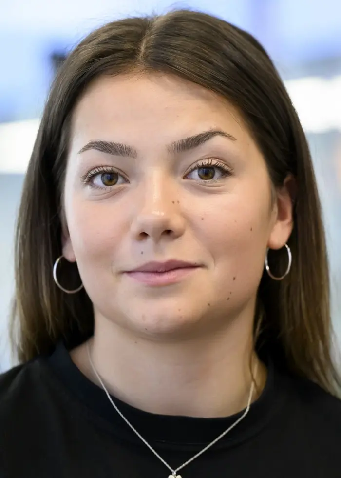 Porträttbild på en yngre kvinna med mörkt hår och svart tröja.