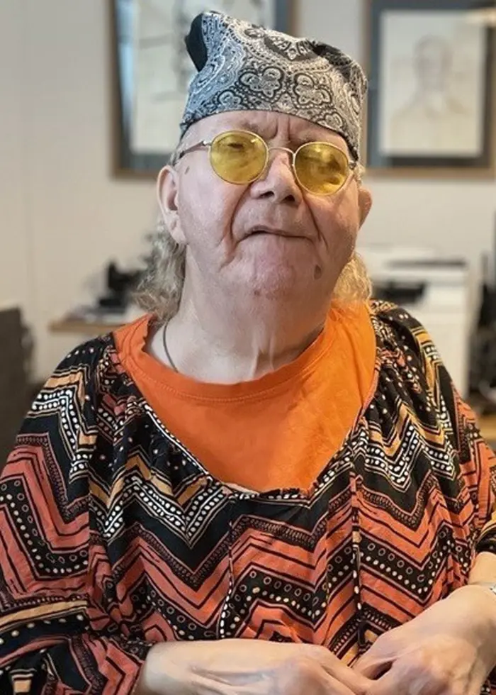 En person sitter i ett rum med datorer och skrivbord i bakgrunden. Personen bär en färgglad mönstrad tröja. Texten 'P4 granskar' syns i bildens övre högra hörn.