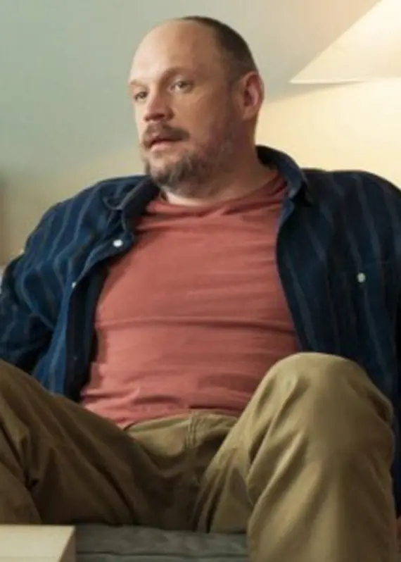 Två personer sitter i ett vardagsrum med en bokhylla, växt och lampa i bakgrunden. En kaffekopp och näsdukar syns på ett soffbord i förgrunden. Bilden är från SVT-serien 'Populära problem'.