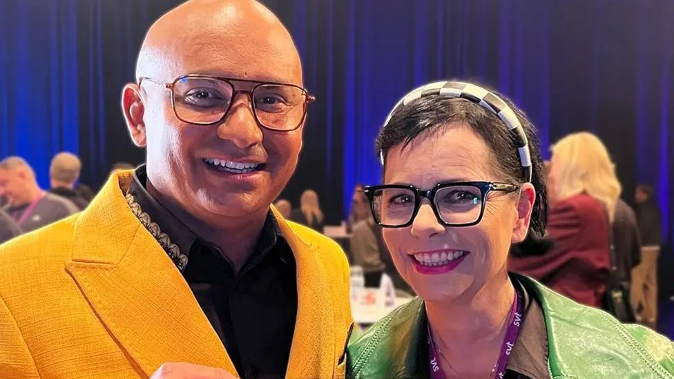 Man i gul kavaj och kvinna i grön jacka.