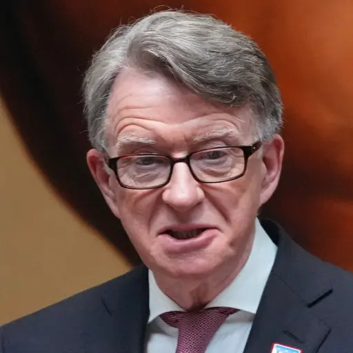 Mandelson i kostym och rosa slips talar vid ett podium med mikrofoner. I bakgrunden syns en del av en hästmålning.