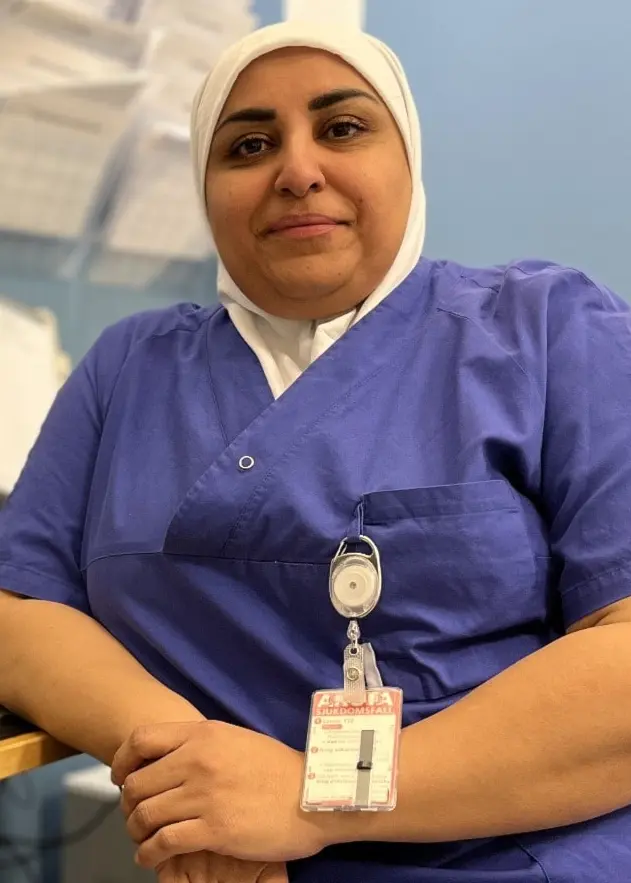 En undersköterska sitter vid ett skrivbord med ler-modeller av exempel på underliv som utsatts för olika typer av könstympningar.