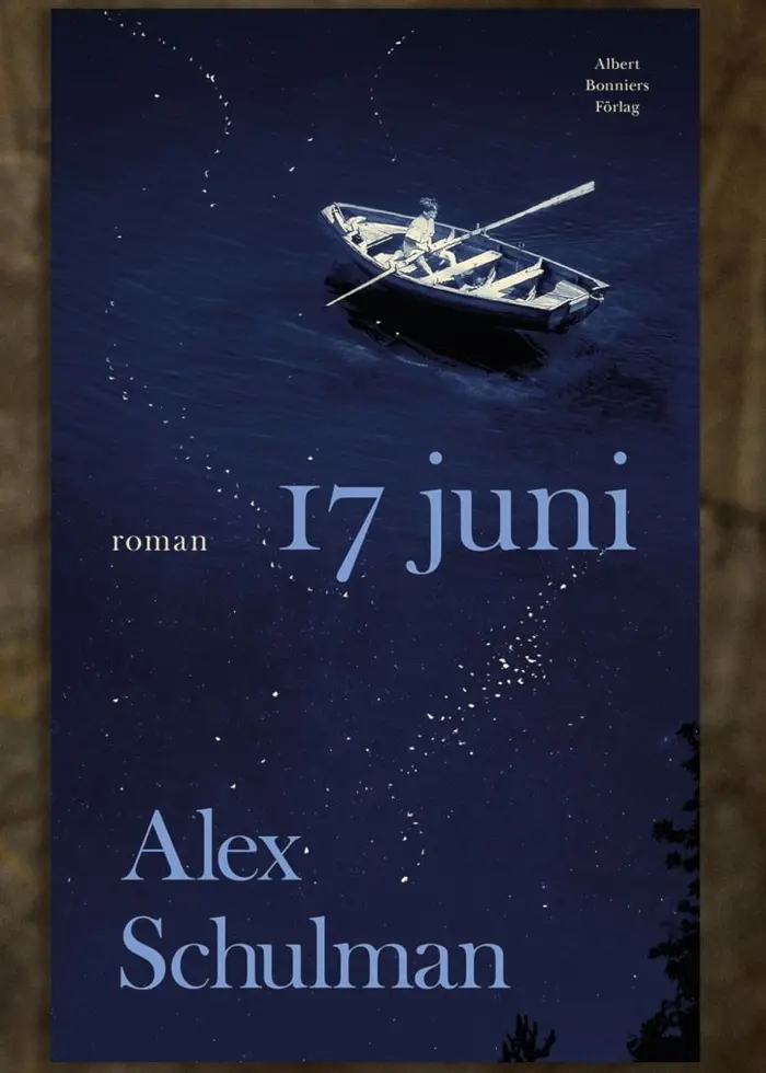 På bilden syns bokens omslag och Alex Schulmans vid en bokhylla med handen mot ansiktet. Bokomslag med texten ”17 juni” ligger infälld i bild. På omslaget ser man en pojke ensam i en eka på vatten.
