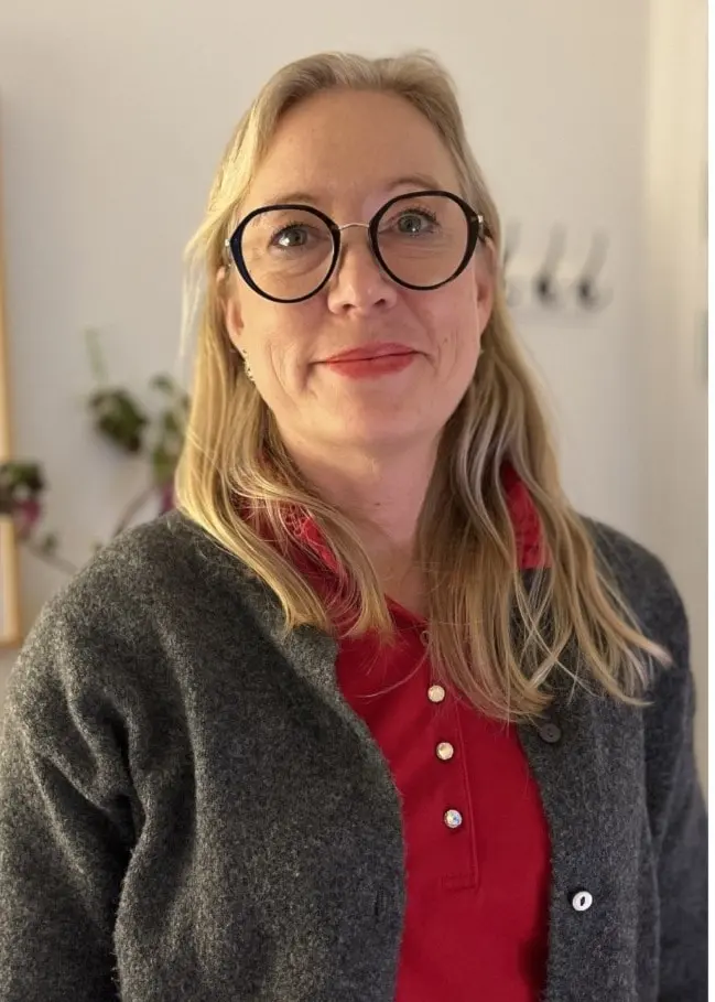 Bildcollage som visar två separata scener. Till vänster en person med svarta, runda glasögon och blont hår iklädd röd tröja och grå kofta stående inomhus. Till höger en stödjande gest där flera händer läggs på axeln av en person i grön tröja.