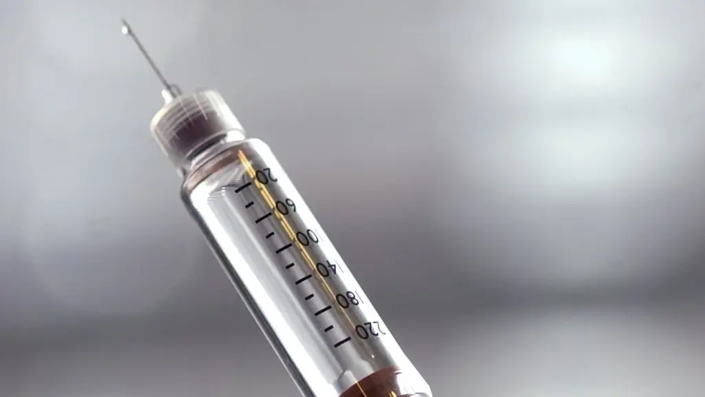 En närbild av en insulinspruta fylld med vätska, med en tydlig nål och graderingsmätning på sprutan. Bakgrunden är suddig i ljusa toner.