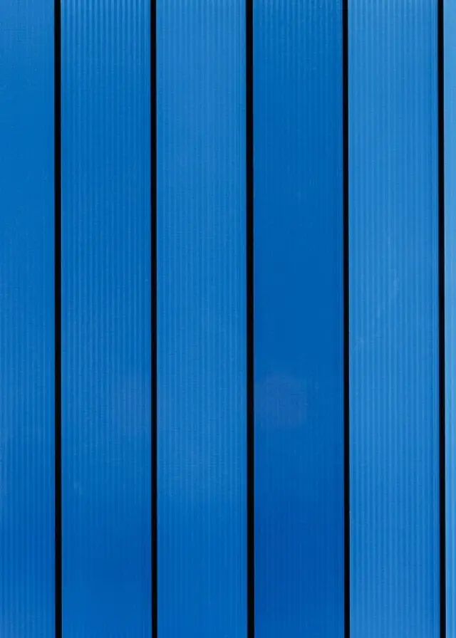 En kvadratisk glasskiva med blåa ränder mot svart bakgrund.