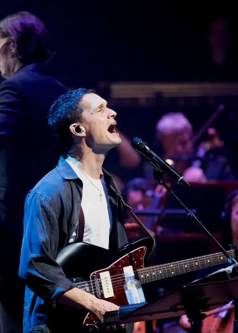 Jonathan Johansson, med elgitarren på magen, sjunger framför Sveriges Radios Symfoniorkester och dirigent Erik Arvinder.